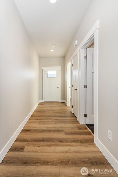 Bright hallway with white walls and wooden flooring in a new home.